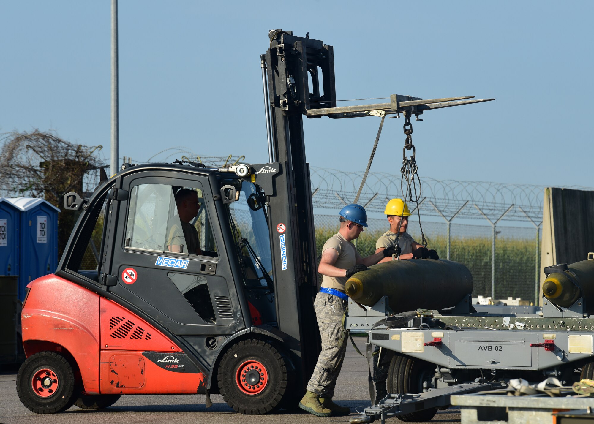 Airmen assist each other in loading munitions onto a trailer during Combat Ammunition Production Exercise 2019 on Aug. 7, 2019, at Aviano Air Base, Italy. Exercises such as CAPEX keep the Airmen of the munitions career field prepared and demonstrates USAFE’s ability to be rapidly ready for contingency operations. (U.S. Air Force photo by Airman 1st Class Caleb House)