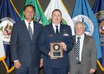 Major Brandon Vogt is recognized with a 2018 Intelligence Community (IC) Acquisition Award in the Systems Engineering category at the IC Campus, in Bethesda, Maryland, on May 6, 2019. Left: Mr. Kevin P. Meiners, Deputy Director of Enterprise Capacity, Office of the Director of National Intelligence; Right: Dr. Roy C. Pettis, Assistant Deputy of National Intelligence for Acquisition, Procurement and Facilities, Office of the Director of National Intelligence.