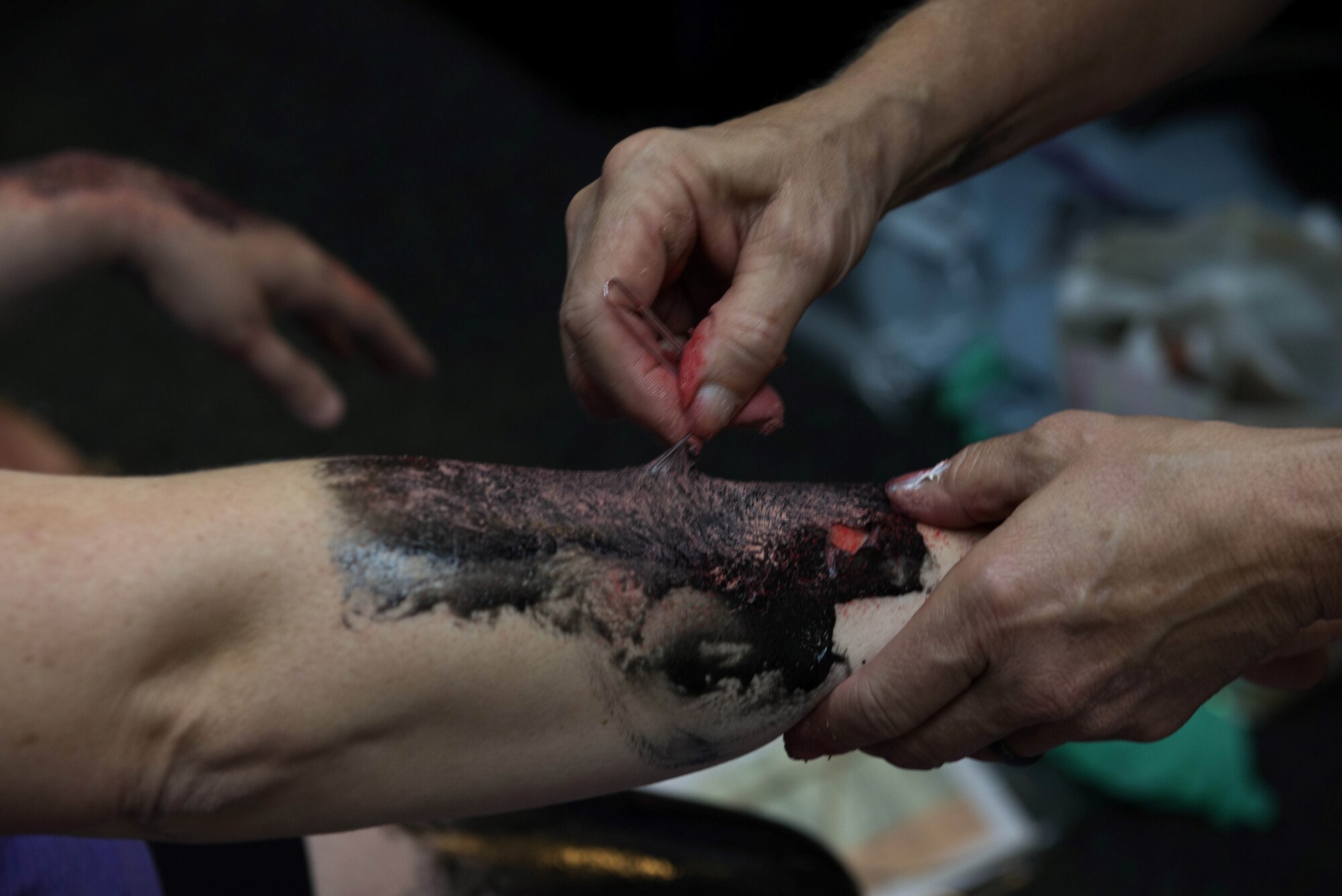 U.S. Air Force Lt. Col. Cheryl Lockhart, 20th Medical Group chief nurse, right, applies moulage to a simulated patient at Shaw Air Force Base, South Carolina, Aug. 1, 2019.
