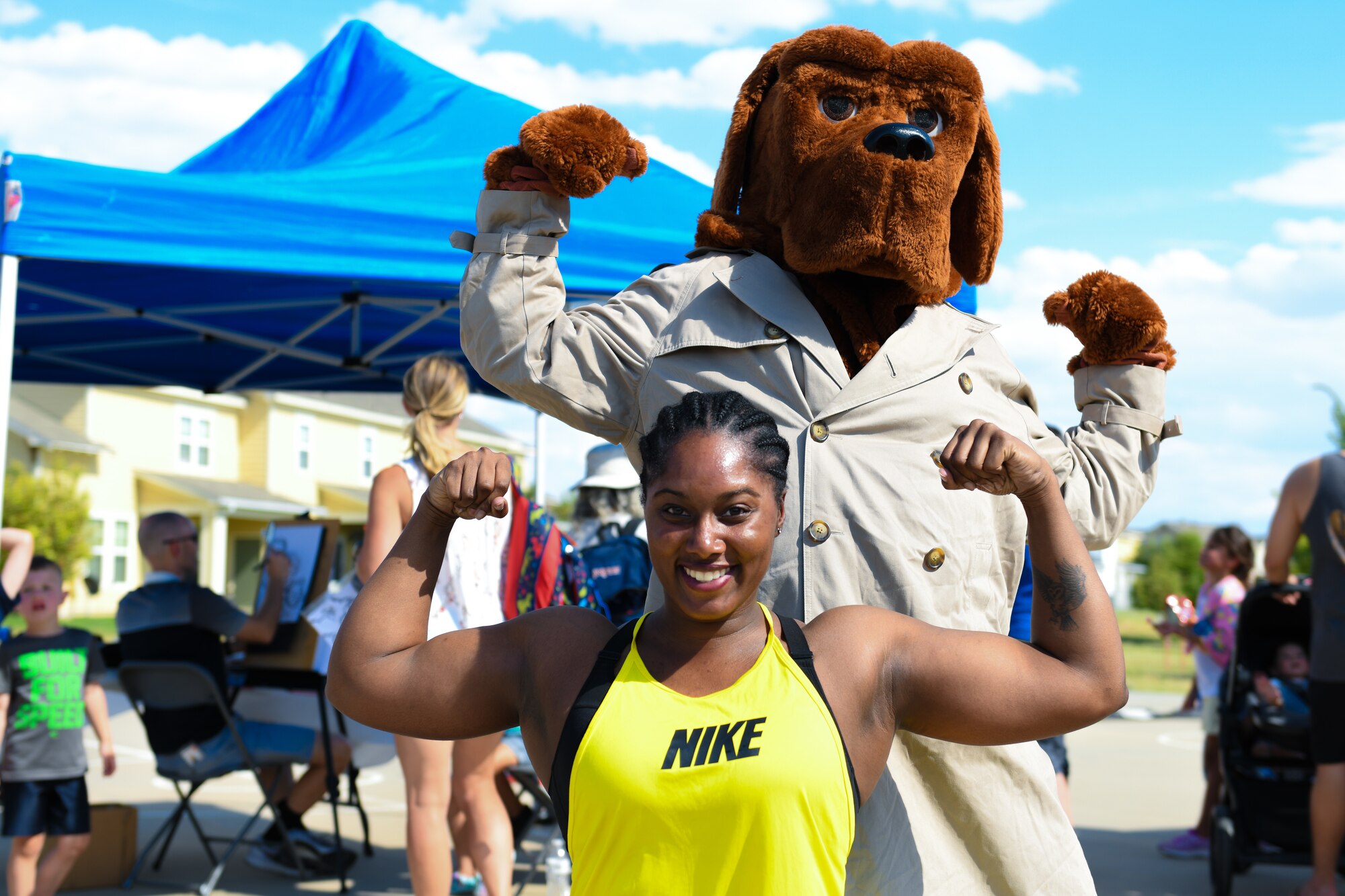 Special Agent Aurielle Owens, Detachment 801, flexes at the National Night Out event, Aug. 6, 2019, on Buckley Air Force Base, Colo. Buckley’s first responders took
a break from fighting crime and came out to the event to bring the community together.