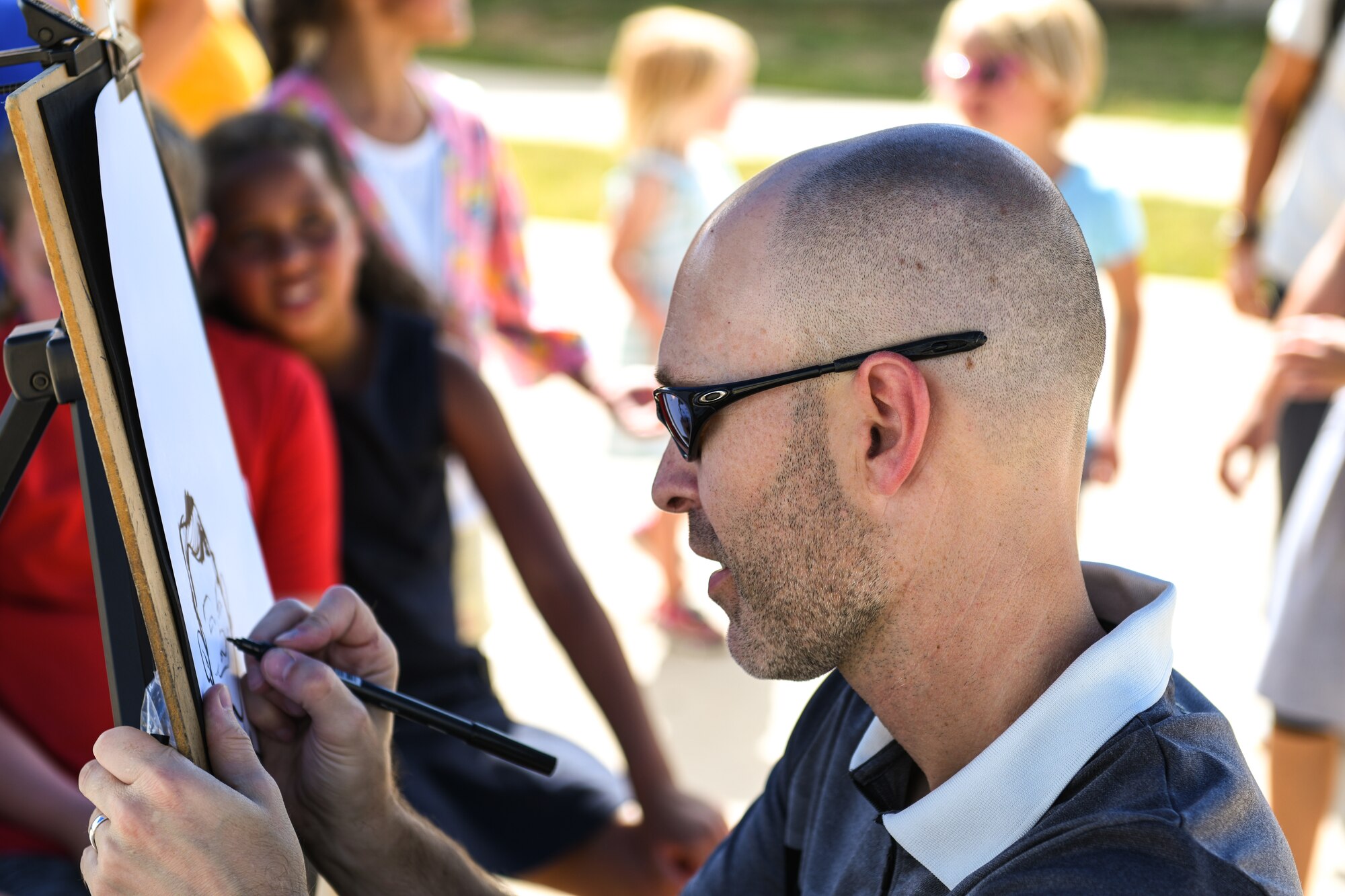 Jason Sauer, a denver caricatures artist, draws a sketch during the National Night Out event, Aug. 6, 2019, on Buckley Air Force Base, Colo. Sauer has 20 years of
caricature drawings experience and does many events around the colorado area. (U.S. Air
Force photo by Airman Andrew I. Garavito)