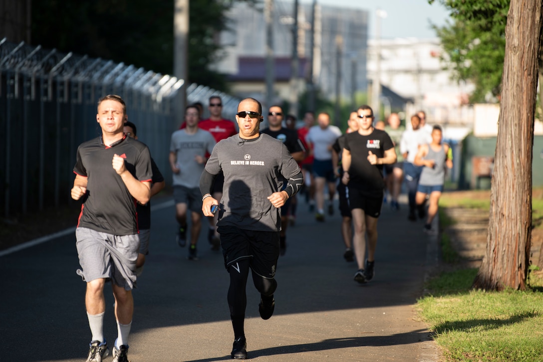 Master Sgt. Ryan Hines (center), 374th Logistics Readiness Squadron Fuels Environmental Safety Office section chief, and members of Team Yokota run during a 5K on Purple Heart Day at Yokota Air Base, Japan, Aug. 7, 2019.