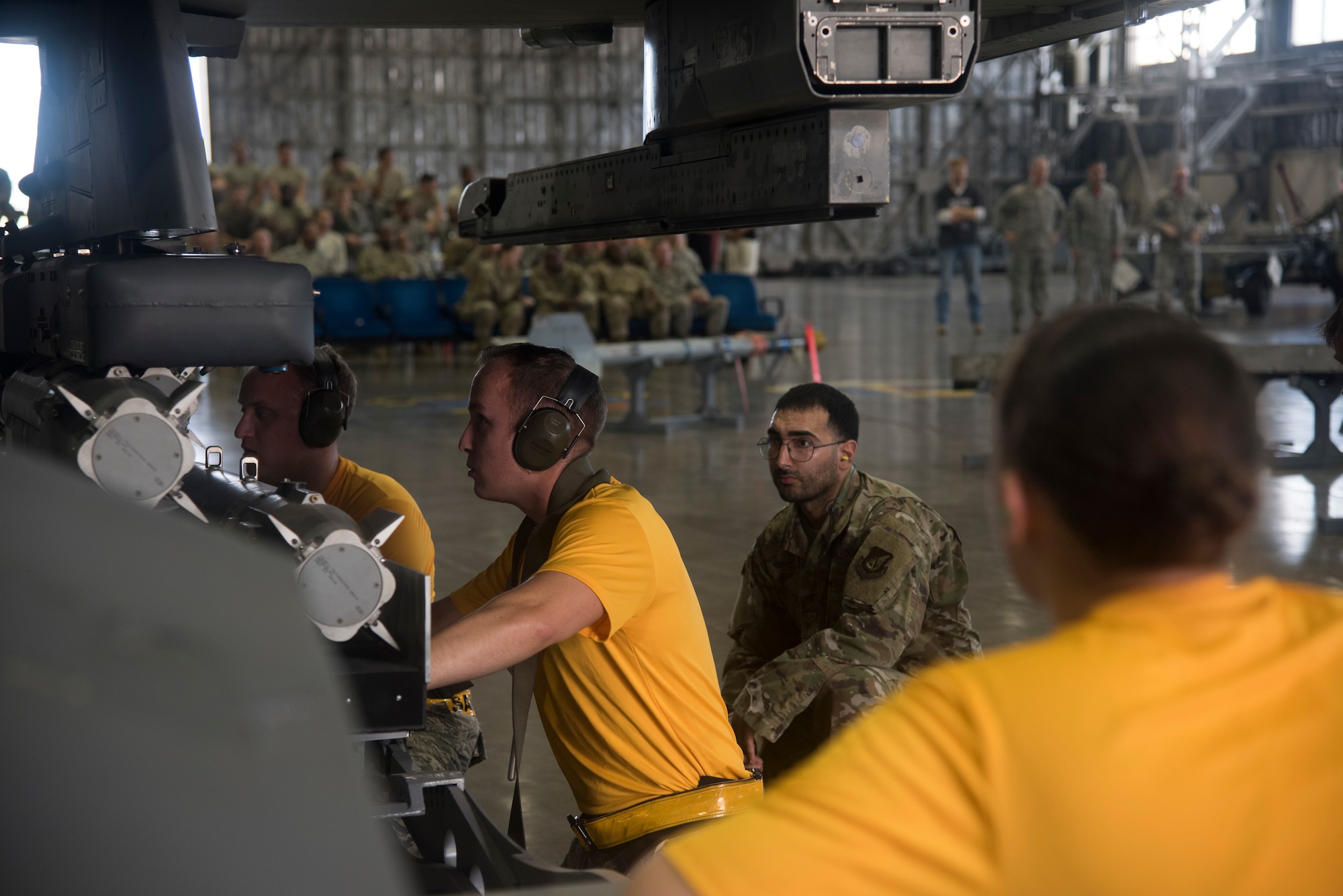 U.S. Air Force Staff Sgt. Hipjunior Cruz, a 35th Maintenance Squadron load crew chief, observes 14th Aircraft Maintenance Unit Airmen loading munitions onto an F-16 Fighting Falcon during the second quarter load crew competition at Misawa Air Base, Japan, Aug. 2, 2019. Expert weapons technicians evaluate participants on various criteria such as safety, accuracy, tool accountability and dress and appearance. (U.S. Air Force photo by Takaharu Daibo)