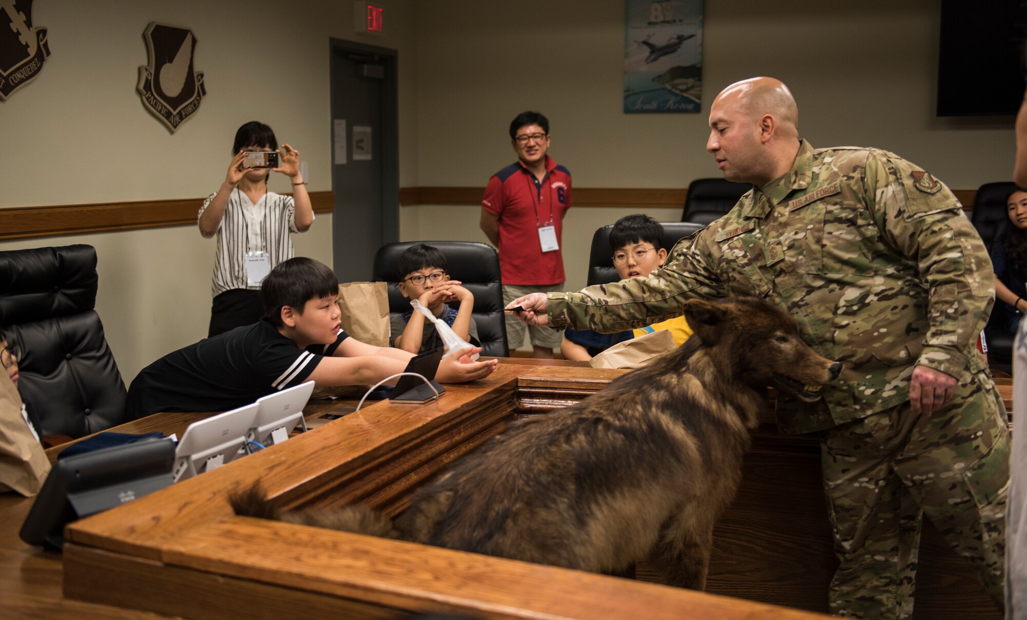 U.S. Air Force Chief Master Sgt. Steve Cenov, 8th Fighter Wing command chief, gives a local Korean child a security forces patch during a tour at Kunsan Air Base, Republic of Korea, Aug. 2, 2019. More than 20 children from the surrounding area were invited to tour the base and visit some of the facilities and organizations, such as the 8th Civil Engineer Squadron fire department. (U.S. Air Force photo by Senior Airman Stefan Alvarez)