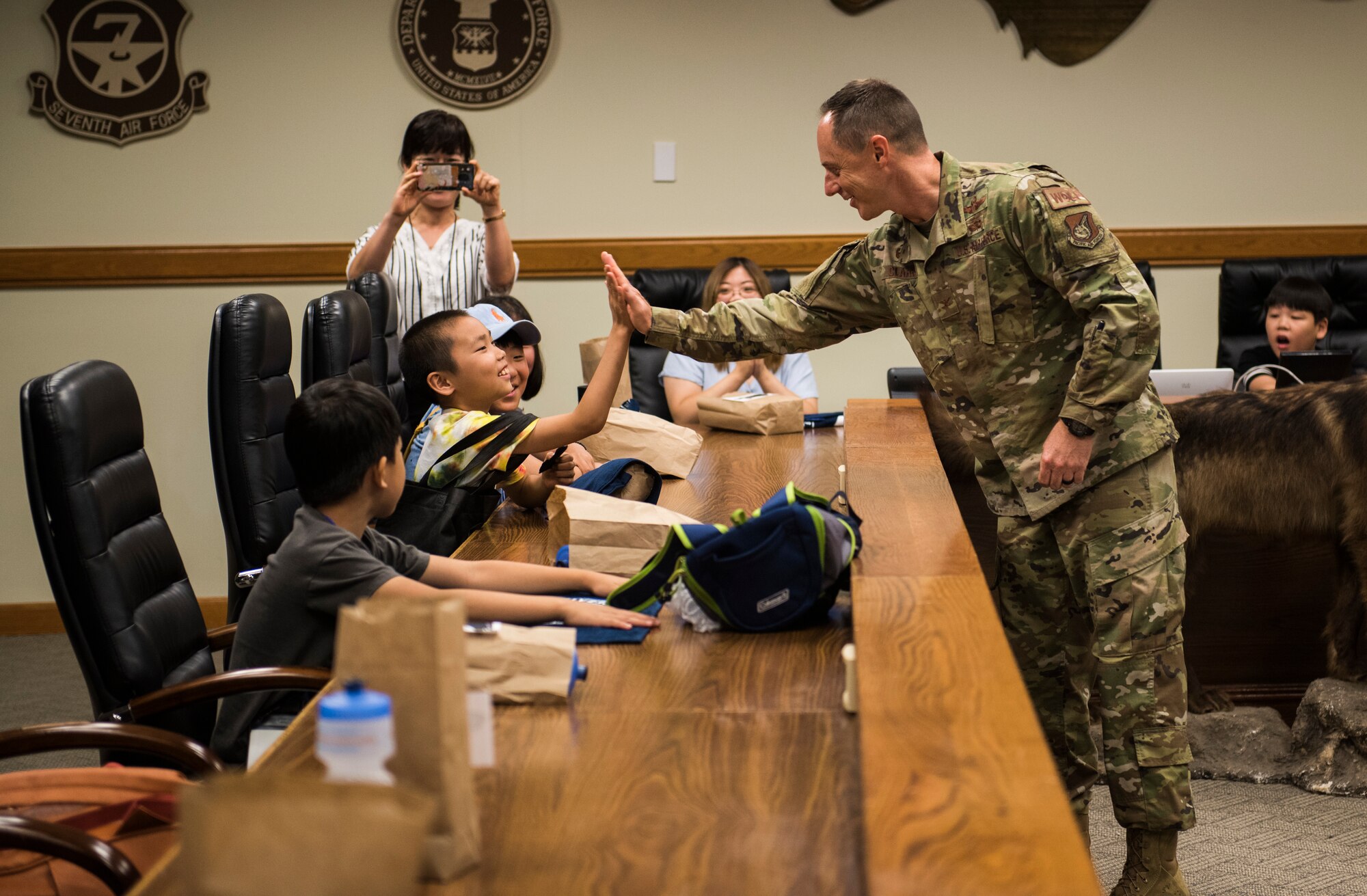 U.S. Air Force Col. Tad Clark, 8th Fighter Wing commander, high fives a local Korean child during a tour at Kunsan Air Base, Republic of Korea, Aug. 2, 2019. More than 20 children from the surrounding area were invited to tour the base and visit some of the facilities and organizations, such as the 8th Civil Engineer Squadron fire department. (U.S. Air Force photo by Senior Airman Stefan Alvarez)