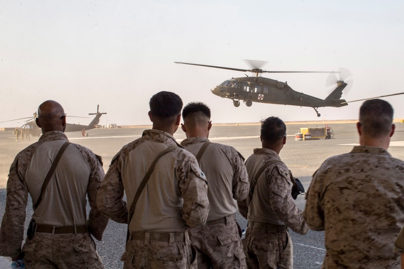 U.S. Sailors with the 11th Marine Expeditionary Unit observe an HH-60M helicopter take off during a joint-service casualty evacuation class at Camp Buehring, Kuwait. The Boxer Amphibious Ready Group and the 11th MEU are deployed to the U.S. 5th Fleet area of operations in support of naval operations to ensure maritime stability and security in the Central Region, connecting the Mediterranean and the Pacific through the Western Indian Ocean and three strategic choke points.