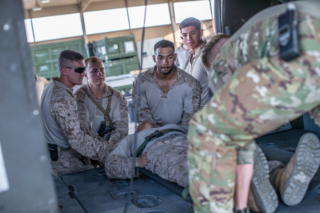 U.S. Sailors with the 11th Marine Expeditionary Unit, and a U.S. Soldier with Golf Company, 5th Battalion, 159th Aviation Regiment load a simulated casualty onto an HH-60M helicopter during a joint-service casualty evacuation class at Camp Buehring, Kuwait. The Boxer Amphibious Ready Group and the 11th MEU are deployed to the U.S. 5th Fleet area of operations in support of naval operations to ensure maritime stability and security in the Central Region, connecting the Mediterranean and the Pacific through the Western Indian Ocean and three strategic choke points.