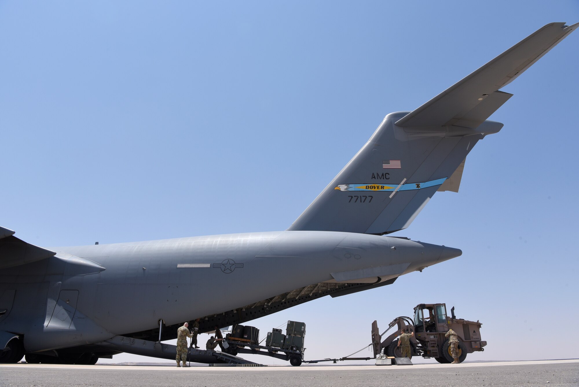 Airmen transporting gear off of a C-17