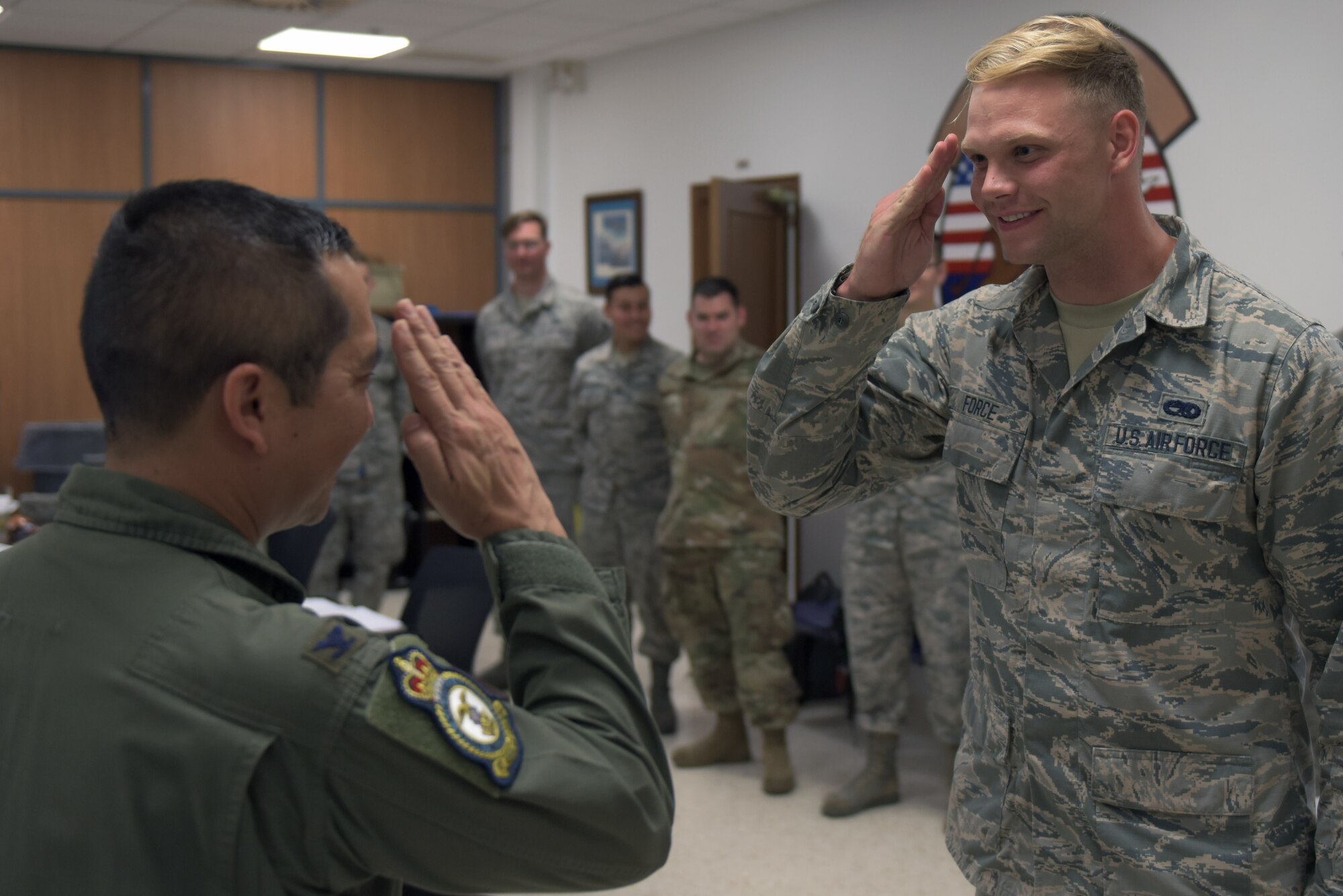 Col. Troy Pananon, 100th Air Refueling Wing commander, salutes Senior Airman Michael Force, 351st Expeditionary Air Refueling Squadron environmental electrical journeyman, at Moron Air Base, Spain, Aug. 6, 2019. Force had just been coined by Pananon for his outstanding work during the deployment. (U.S. Air Force photo by Senior Airman Benjamin Cooper)