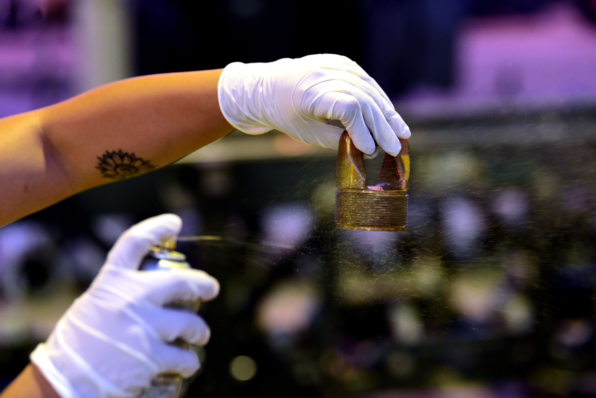 An Airman sprays lubricant on a suspension lug during Combat Ammunition Production Exercise 2019 on Aug. 7, 2019, at Aviano Air Base, Italy. Suspension lugs to attach munitions to aircraft allowing the 31st Fighter Wing to stay lethal and rapidly ready. (U.S. Air Force photo by Airman 1st Class Caleb House)