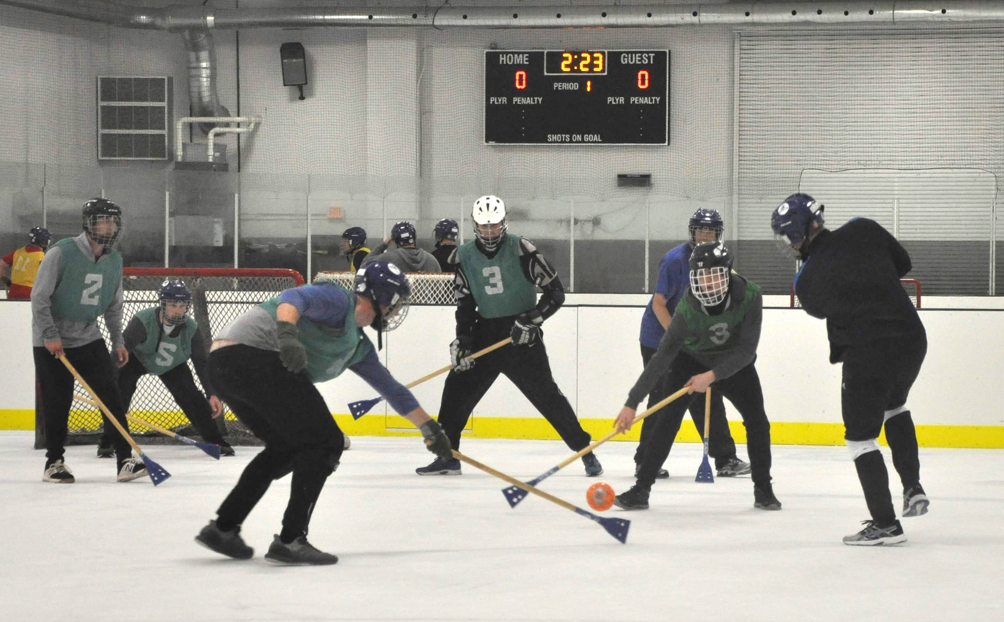 Members of the 38th Reconnaissance Squadron fight for the ball during a game of Broomball June 21, 2019, at Grover Ice Rink, Omaha, Nebraska. The squadron participated in this unit cohesion event funded by the Unite Program. The program is the vision of Gen. David L. Goldfein, Air Force chief of staff, who recognized the need to take care of our squadrons by allowing units to focus on resiliency and cohesion for its members.