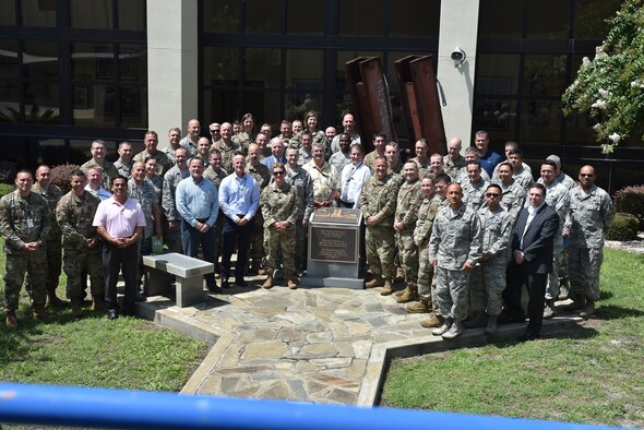 Participants from the Continental U.S. NORAD Region - 1st Air Force (Air Forces Northern) 2019 Cyber Summit take a break for a photo opportunity at the 9-11 Memorial on the grounds of the 601st Air Operations Center. (Air Force photo by Mary McHale)