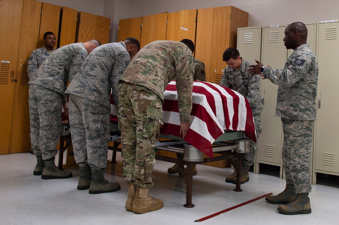 Tech. Sgt. Jamaal Smalls, right, NCO in charge (NCOIC) of Honor Guard, critiques six-person flag-fold training, July 25, 2019, at Moody Air Force Base, Ga. Smalls has been the NCOIC of Honor Guard since January 2019. (U.S. Air Force photo by Airman Azaria E. Foster)