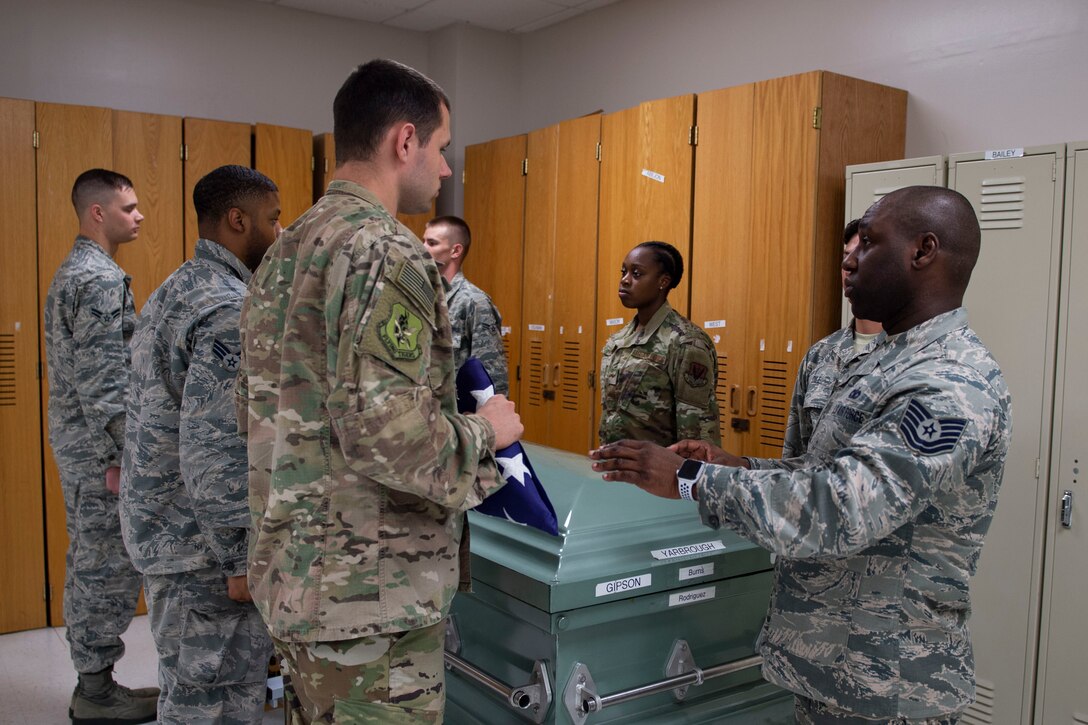 Tech. Sgt. Jesse Larson, left, NCO in charge (NCOIC) of Honor Guard, hands the flag to Tech. Sgt. Jamaal Smalls, NCOIC of Honor Guard, during six-person flag-fold training, July 25, 2019, at Moody Air Force Base, Ga. Smalls’ experience as a master military training instructor helped him develop his professionalism and attention to detail that he now uses in Honor Guard. (U.S. Air Force photo by Airman Azaria E. Foster)