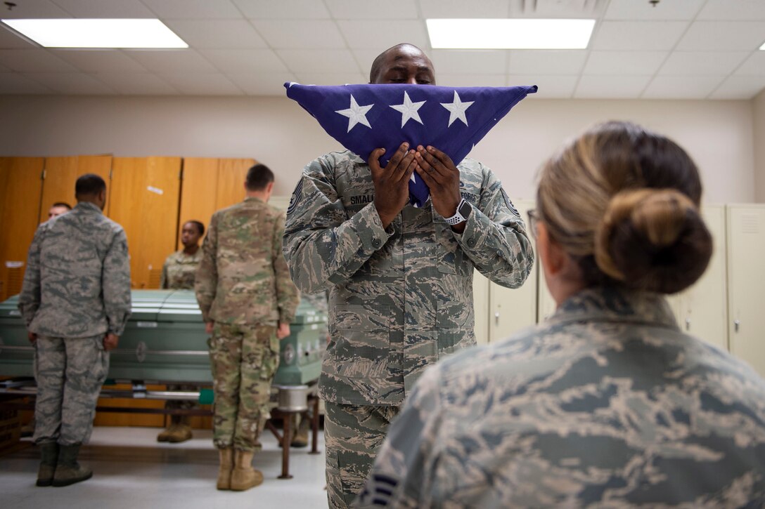 Tech. Sgt. Jamaal Smalls, NCO in charge of Honor Guard, holds the flag during six-person flag-fold training, July 25, 2019, at Moody Air Force Base, Ga. Smalls’ experience as a master military training instructor helped him develop his professionalism and attention to detail that he now uses in Honor Guard. (U.S. Air Force photo by Airman Azaria E. Foster)