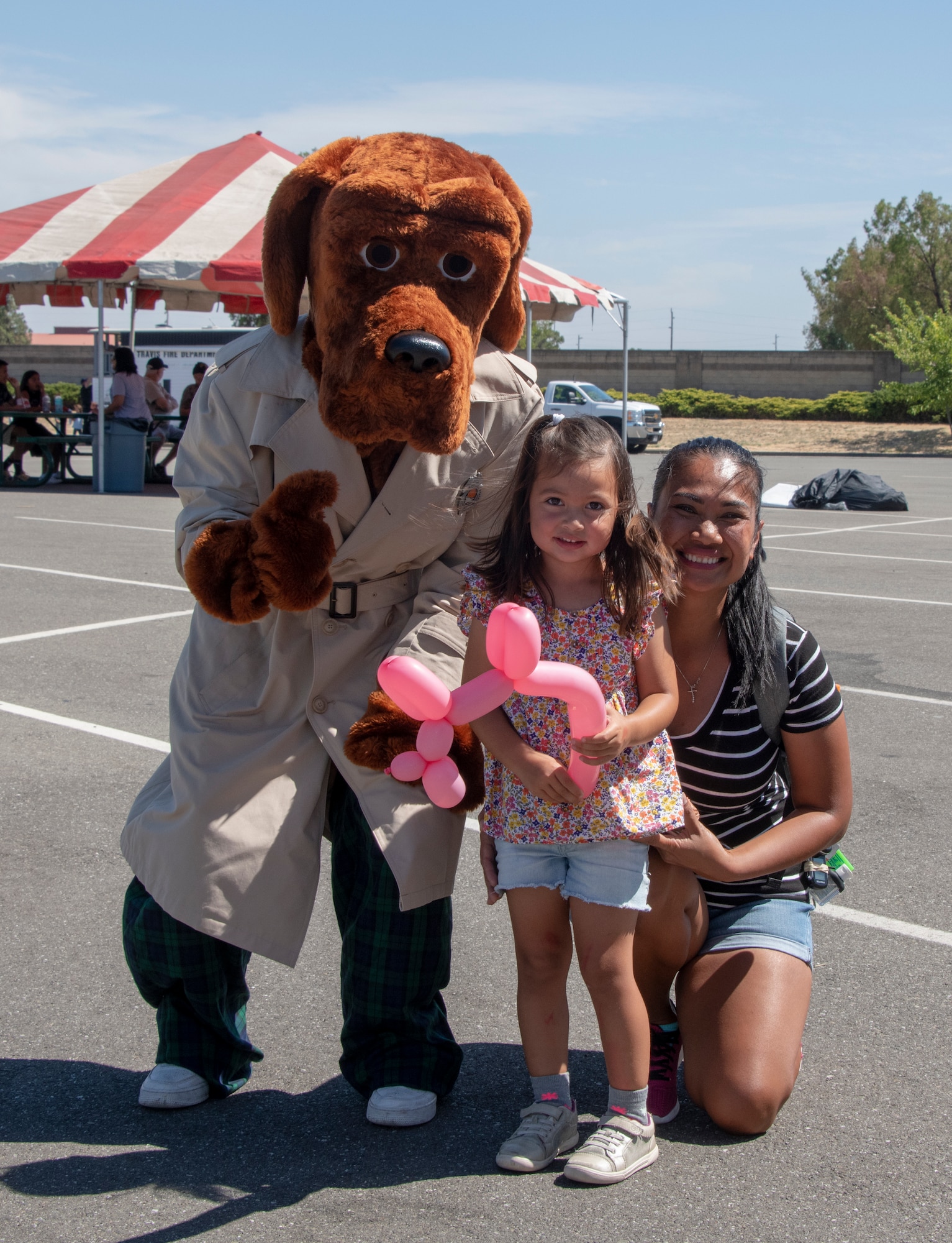 Mcgruff the Crime Dog pauses to take a picture with Team Travis community members during the 60th Security Forces Squadron National Night Out Aug. 6, 2019, at Travis Air Force Base, California. National Night Out is an annual community-building campaign that promotes police-community partnerships and neighborhood camaraderie. The event included a demonstration by military working dogs, live music and a variety of activities for children. (U.S. Air Force photo by Heide Couch