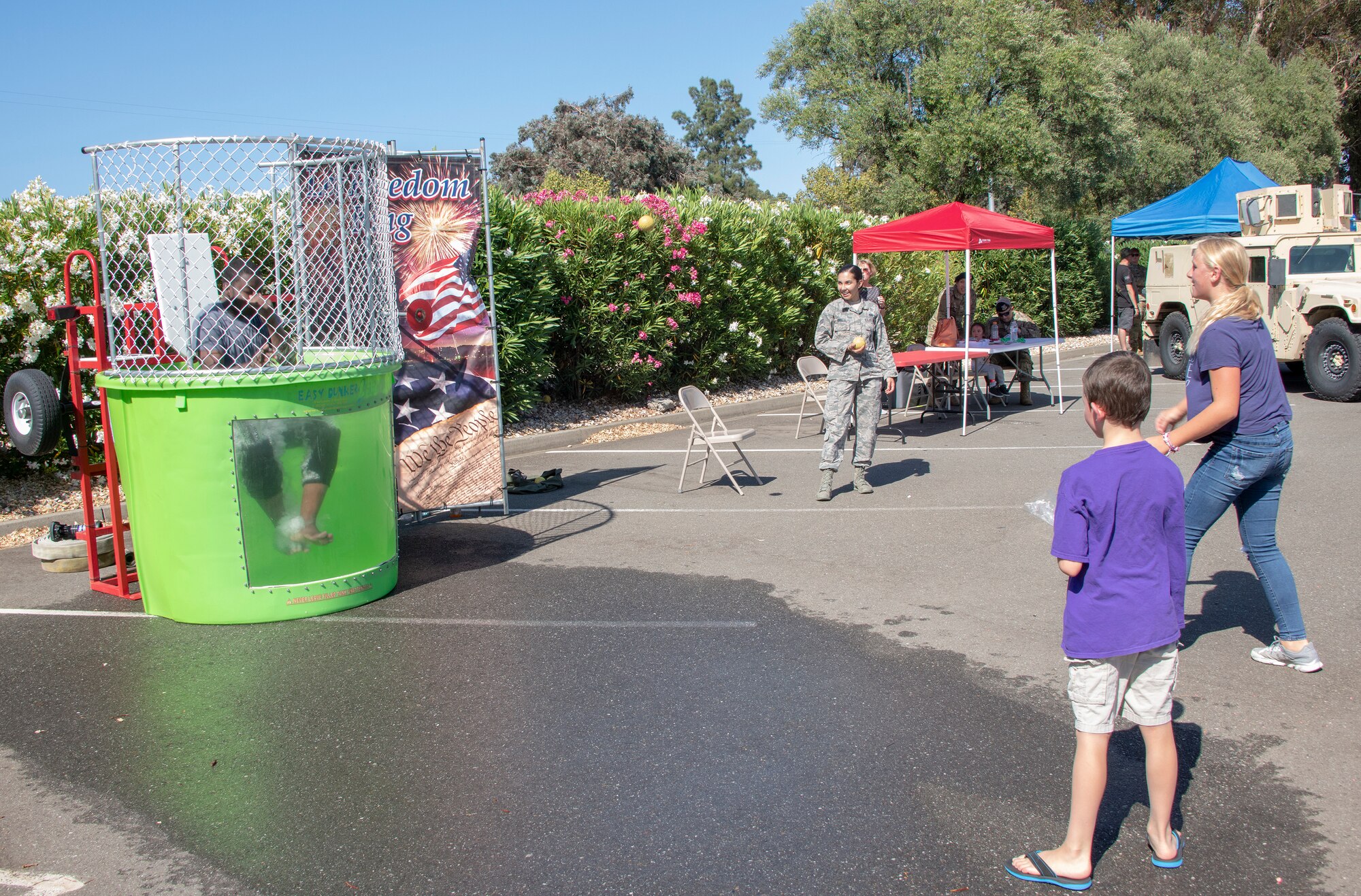 U.S. Air Force Senior Airman Isaiah Johnson, 60th Security Forces Squadron installation patrolman, gets dunked in a dunk tank by an event participant during the 60th SFS National Night Out Aug. 6, 2019, at Travis Air Force Base, California. National Night Out is an annual community-building campaign that promotes police-community partnerships and neighborhood camaraderie. The event included a demonstration by military working dogs, live music and a variety of activities for children. (U.S. Air Force photo by Heide Couch)