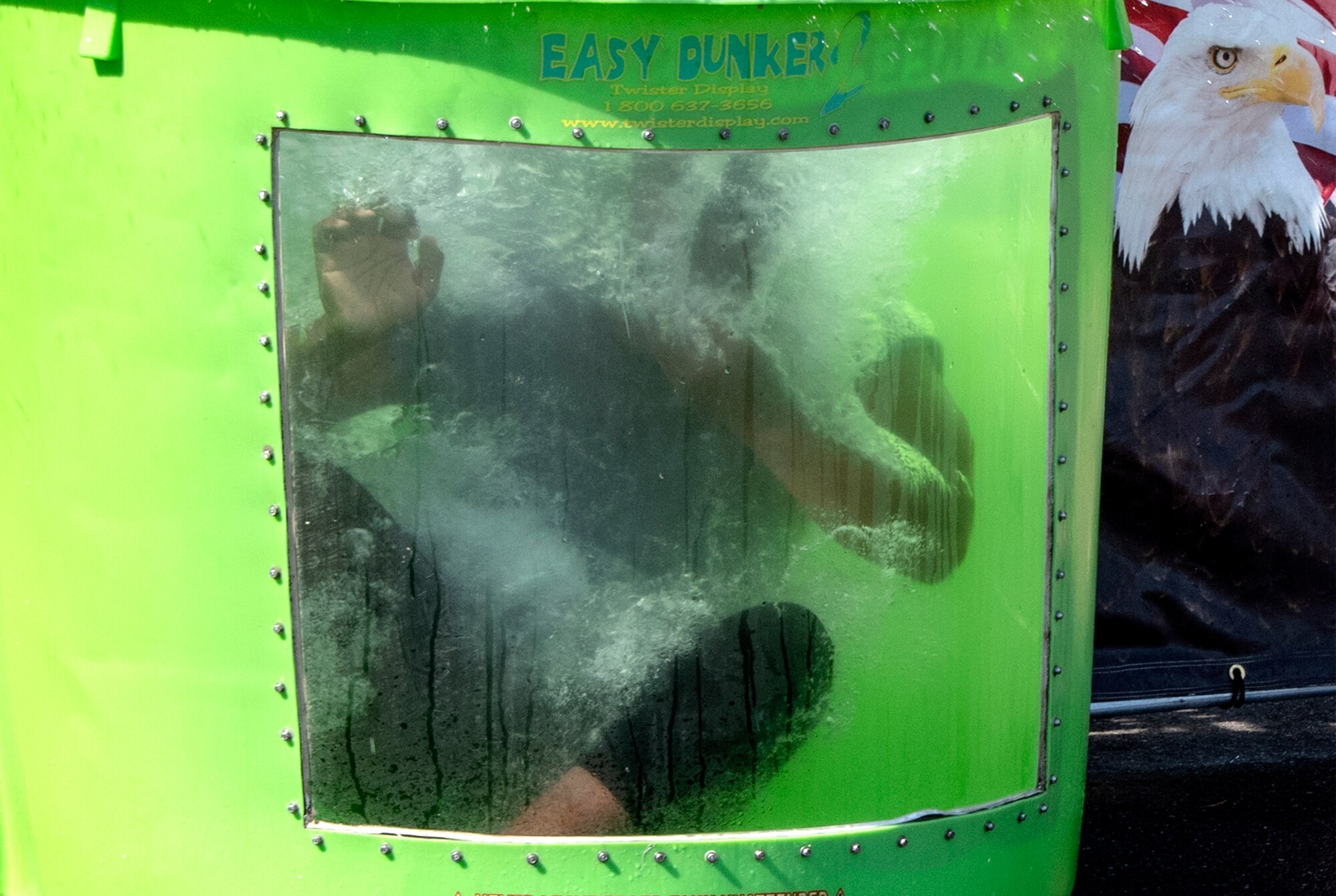 U.S. Air Force Senior Airman Isaiah Johnson, 60th Security Forces Squadron installation patrolman, gets dunked in a dunk tank by an event participant during the 60th SFS National Night Out Aug. 6, 2019, at Travis Air Force Base, California. National Night Out is an annual community-building campaign that promotes police-community partnerships and neighborhood camaraderie. The event included a demonstration by military working dogs, live music and a variety of activities for children. (U.S. Air Force photo by Heide Couch)