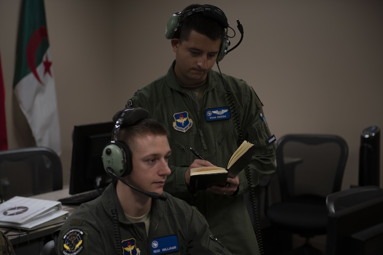 U.S. Air Force Capt. Ryan Oweida, right, Undergraduate ABM Course instructor, helps a student at Tyndall Air Force Base, Florida, Aug. 6, 2019. In the Combat Air Forces, students have the ability to plan, brief, execute and debrief all in the same system on the same day for 60 plus events, helping to reduce the time for training in the course. (U.S. Air Force photo by Airman 1st Class Heather Leveille)