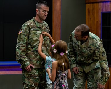 Molly and Kate Little of Pleasant Plains, Illinois, pin the rank of Chief Warrant Officer 4 on their father Ryan Little, the Senior Maintenance Officer, Joint Force Headquarters. Lt. Col. Kevin Little, Deputy Chief of Staff - Logistics, Illinois National Guard, officiated the ceremony.