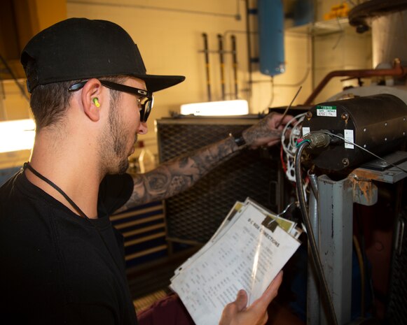 Teddy Mendez, Heavy Mobile Equipment Mechanic, checks specifications for the Dyno wiring as part of the performance testing on a Paxman engine, in the Engine Shop at Production Plant Barstow, Marine Depot Maintenance Command, on the Yermo Annex aboard Marine Corps Logistics Base Barstow, Calif., July 30. The Dyno is capable of replicating real-life circumstances under various and arduous conditions to ensure that the engines perform optimally out at sea.