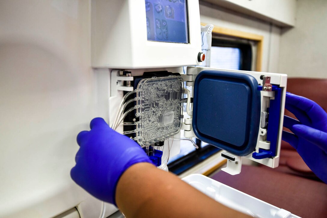 A collection specialist from the Arkansas Blood Institute prepares equipment to draw blood from an Airman during the blood drive at Little Rock Air Force Base, Ark., August 4, 2019. The blood donation is a four-step process: registration, medical history and mini-physical, followed by the donation. Each donation of 1-pint can contribute to saving up to 3 lives. While Airmen’s main focus is readiness training during Unit Training Assembly, the blood drive allowed Airmen to take a break from training and give back to the community. (U.S. Air Force photo by Senior Airman Nathan Byrnes)