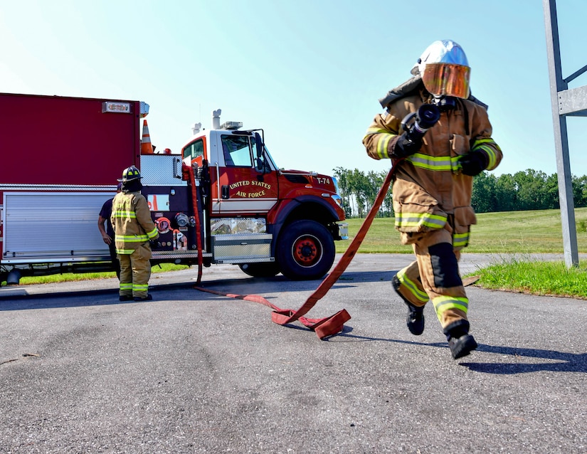 A cadet runs with a fire hose during a demonstration on the last day of the Fire Explorer Program on Joint Base Andrews, Md., July 27, 2019. Each cadet was challenged to perform search and rescue procedures, CPR, operate a fire hose, and put out a controlled fire in a timely manner.