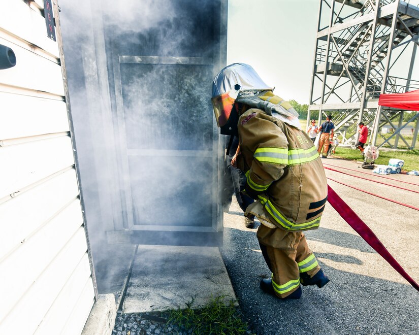A cadet runs into a smoke filled building to demonstrate his proficiency in the search and rescue skills taught during the Fire Explorer Program on Joint Base Andrews, Md., July 27, 2019. During this challenge, cadets were expected to navigate a smoke-filled building to find a hidden manikin and return it to safety.