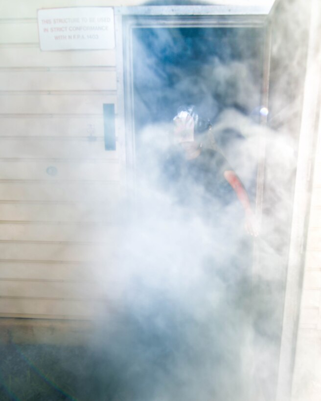 Cameron Ordonez, Fire Explorer Academy cadet, emerges from a smoke-filled room after completing the search and rescue challenge on Joint Base Andrews, Md., July 27, 2019. Following the challenge, cadets received a certificate of completion for the course and were considered CPR/AED certified by the American Red Cross Foundation.