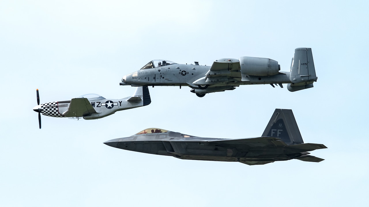 Air Force heritage flight of aircraft; an F-22 Raptor, P-51 Warhawk and A-10 Thunderbolt II flying together