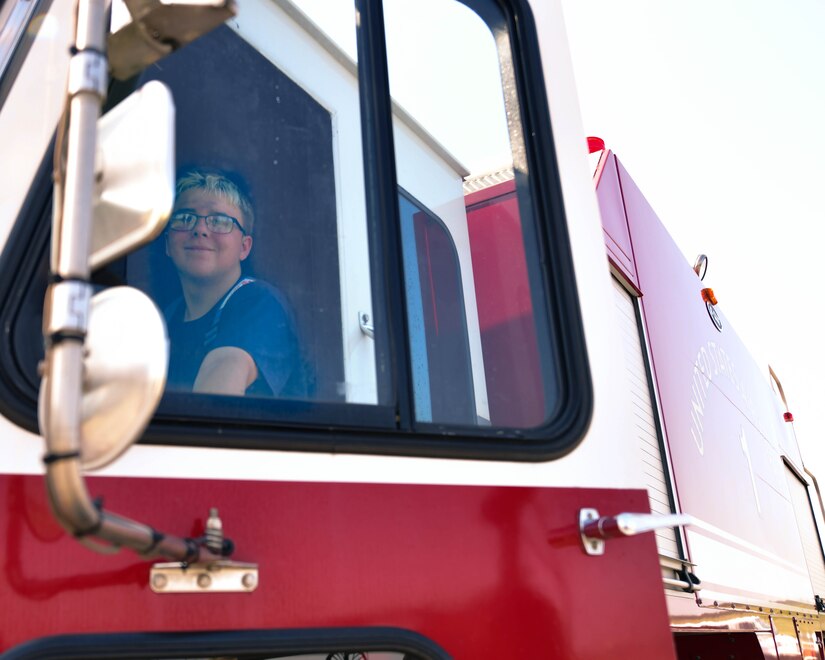 Tristan Jolley, Fire Explorer Academy cadet, opens a fire truck door during an exercise on Joint Base Andrews, Md., July 27, 2019. On the final day of the academy, Jolley and 10 other cadets demonstrated the skills they learned during the 6-day long program.