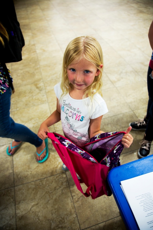 Jaidyn Wright, daughter of Staff Sgt. Steven Wright and his wife Leah, displays her belief in Unicorns and the Back To School Brigade’s school supply giveaway at the annual event held at the Maj. Gen. James L. Day Conference Center aboard Marine Corps Logistics Base Barstow, California, Aug. 1.