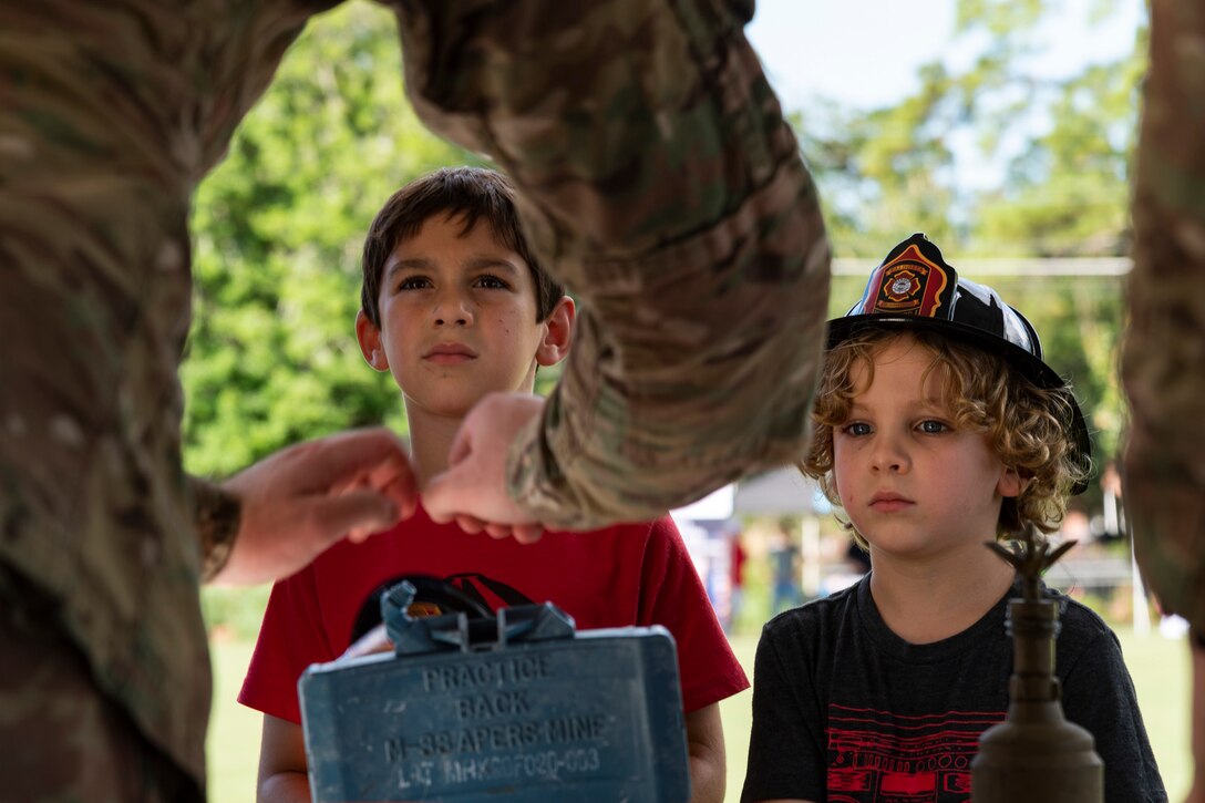 An Airman assigned to the 23d Civil Engineer Squadron (CES) performs an explosives ordnance disposal demonstration for participants of National Night Out at the main campus of Valdosta State University Aug. 6, 2019, in Valdosta, Ga. National Night Out is an annual event that promotes relationships between police and the community in an effort to prevent crime. Representatives from Team Moody participated to create local community awareness and build support for the Air Force mission. (U.S. Air Force photo by Airman 1st Class Hayden Legg)
