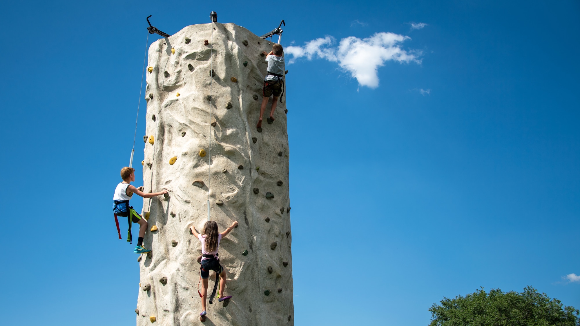 Children ascend a climbing wall during the annual Salute Picnic at Hill Air Force Base, Utah, Aug. 2, 2019. This was the 19th year the Top of Utah Military Affairs Committee sponsored the event for Hill's military and family members. The first event was held December 2001 as a welcome home celebration for military deployed following 9/11. (U.S. Air Force photo by R. Nial Bradshaw)