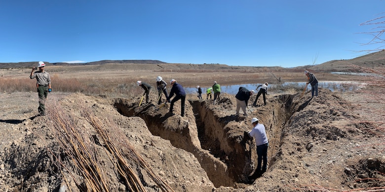 COCHITI LAKE, N.M. - Participants work to dig a heron foot trench at Cochiti Lake during the hands-on riparian construction workshop held February 26-27. The trench is being dug in preparation for planting the freshly-cut willow and cottonwood plantings. The heron foot trench, which resembles the shape of a heron’s footprint, was accomplished using a backhoe.
