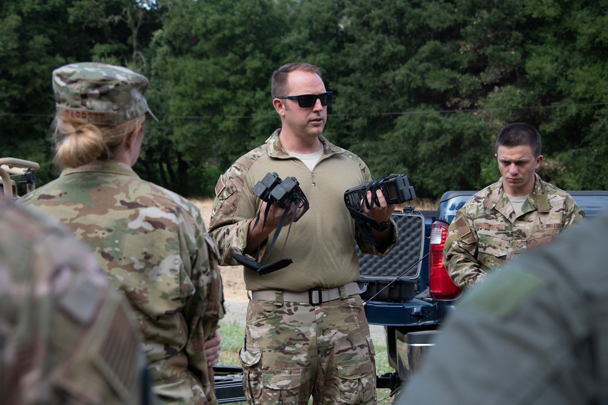 U.S. Air Force Tech. Sgt. Benjamin Heard, 60th Operations Squadron survival, evasion, resistance and escape training NCO officer in charge gives last minute instruction on communication devices before a SERE training exercise for aircrew members that will last well into the evening, Aug. 5, 2019 in a remote area near Travis Air Force Base, California. SERE instructors conduct the training to improve aircrew’s skill sets and update them on new techniques, procedures and technologies. (U.S. Air Force photo by Heide Couch)