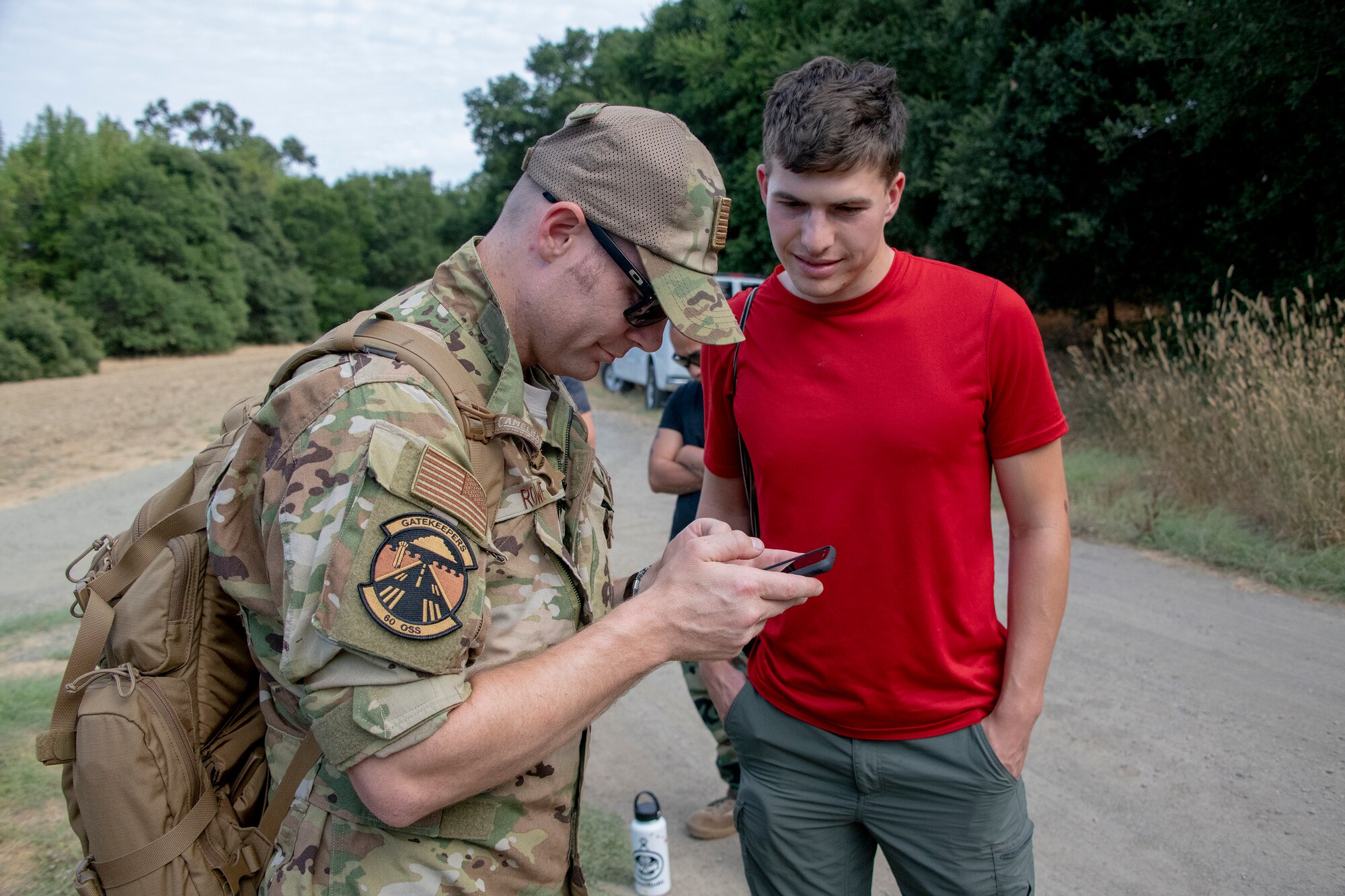 U.S. Air Force Tech. Sgt. Bernie Rowe, 60th Operations Support KC-10 Extender instructor flight engineer, and Nate Simon, Somewear Labs product manager, review procedures for new communications technology during a Survival, Evasion, Resistance and Escape Aug. 5, 2019, near Travis Air Force Base, California. Trainees followed SERE instructors point-to-point to learn the process of gathering materials, seeking shelter, discarding unnecessary supplies, finding food and testing improved communication equipment. (U.S. Air Force photo by Heide Couch)