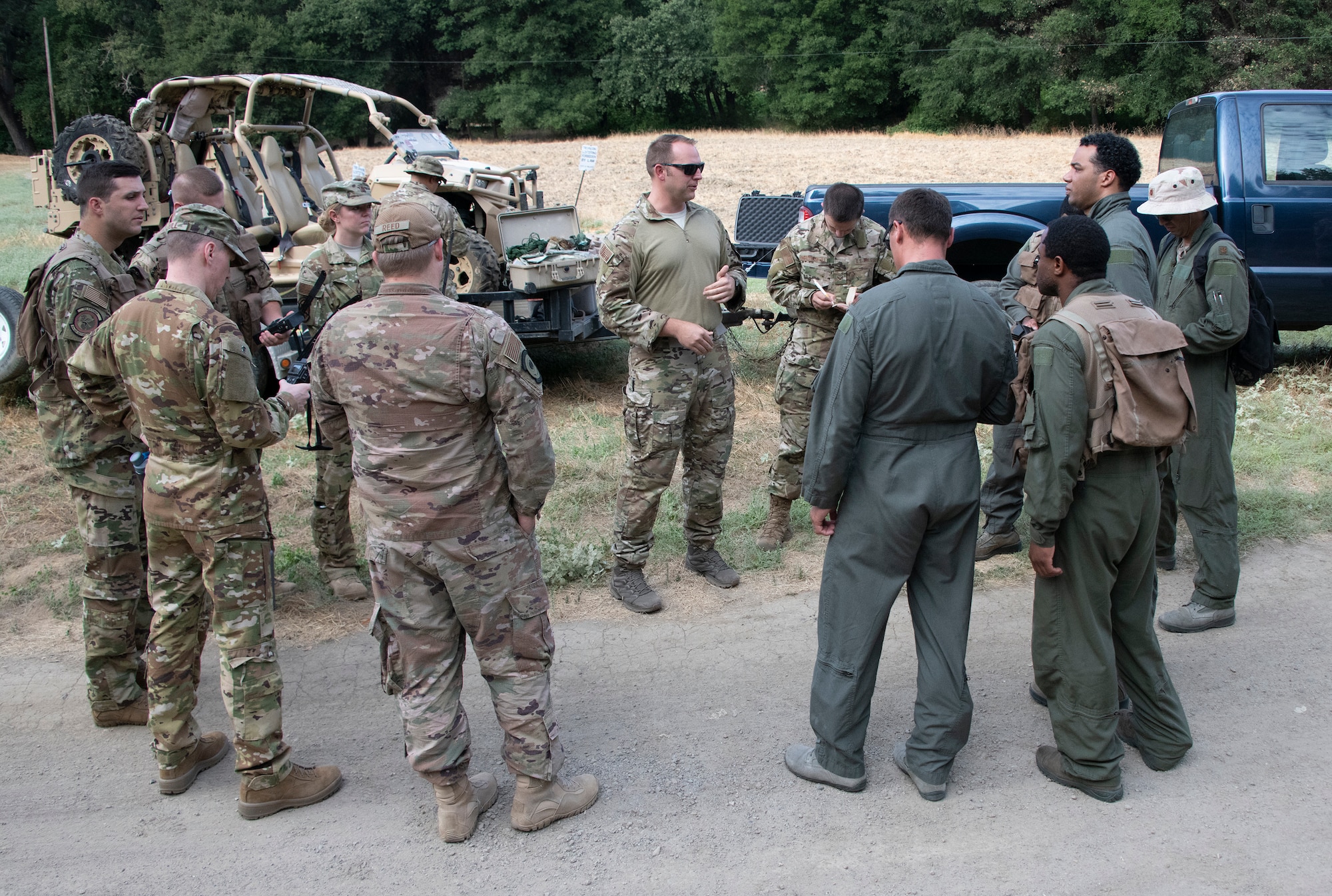 U.S. Air Force Tech. Sgt. Benjamin Heard, center, 60th Operations Squadron Survival, Evasion, Resistance and Escape training noncommissioned officer in charge gives last minute instruction on communication devices before a SERE training exercise for aircrew members, Aug. 5, 2019 in a remote area near Travis Air Force Base, California. SERE instructors conduct the training to improve aircrew’s skill sets and update them on new techniques, procedures and technologies. (U.S. Air Force photo by Heide Couch)