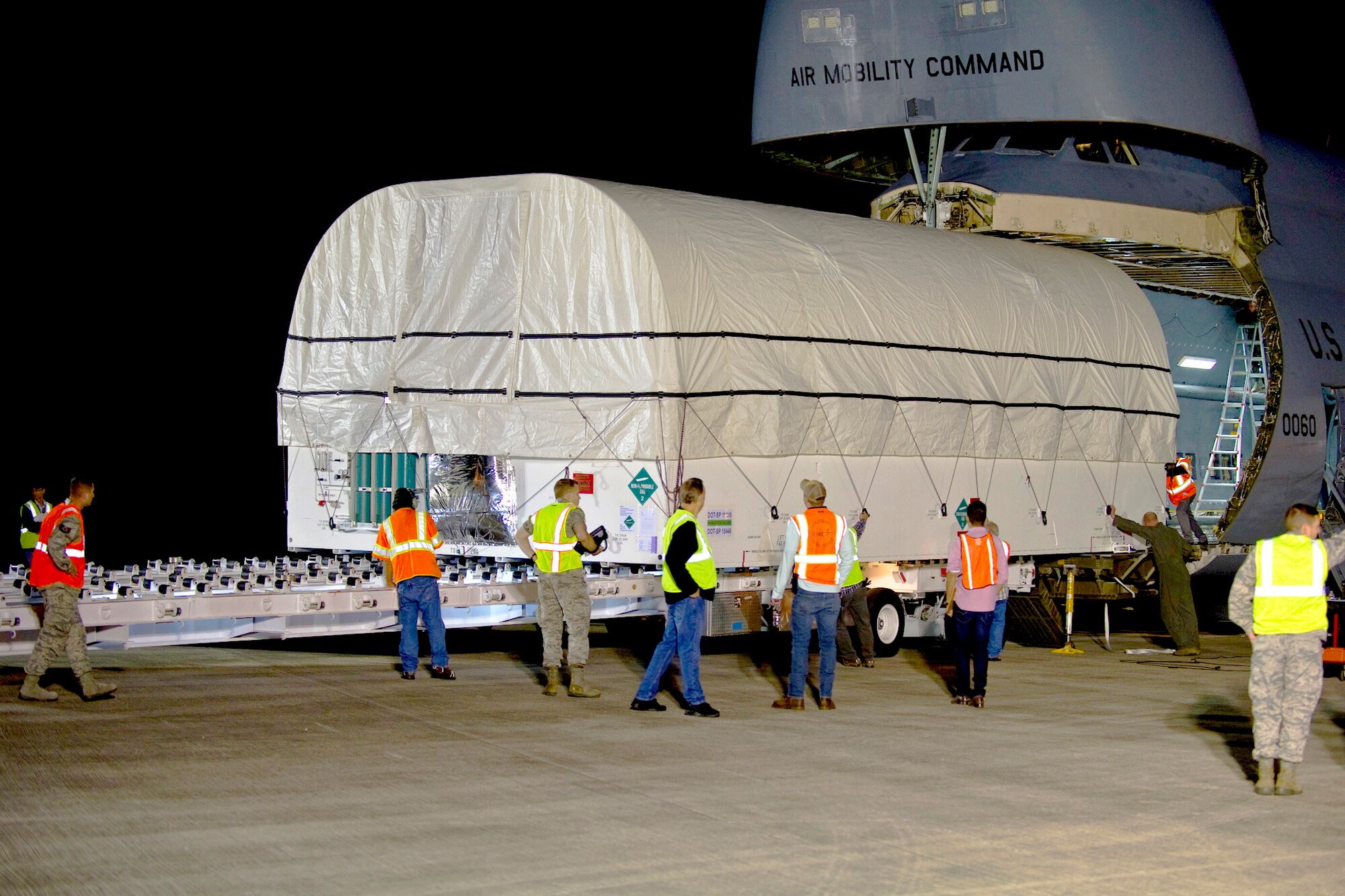 The air crew from the C-5C Galaxy, 22nd Airlift Squadron, from Travis Air Force Base, Calif., members of the Space and Missile Systems Center, the 45th Space Wing, and civilian ground crews, unload the fifth Advanced Extremely High Frequency (AEHF-5) communications satellite, at Cape Canaveral, Fla., April 22, 2019. The AEHF constellation is designed to replace the Milstar satellite constellation. (U.S. Air Force photo by Ian Bush)