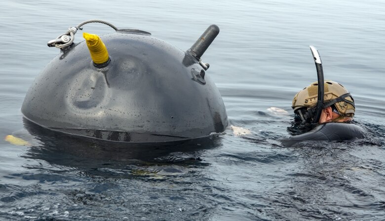 Lt. Andrew Kuo, from Durham, North Carolina, assigned to Explosive Ordnance Disposal Mobile Unit (EODMU) 5 Platoon 501, attaches a dummy explosive charge to floating mine during Mine Warfare Exercise (MIWEX) 2JA. MIWEX 2JA is part of an annual series of bilateral exercises held between the U.S. and Japan to increase proficiency in mine countermeasure operations.