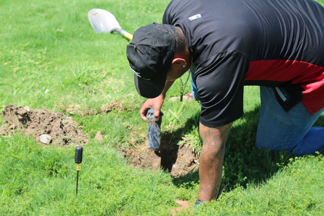 Jerry Piper Jr., laborer, removes an older sprinkler head in the process of swapping it out for a newer, more water efficient sprinkler head on Sorensen Field as part of the Water Conservation Program aboard Marine Corps Logistics Base Barstow, Calif., Aug. 5.