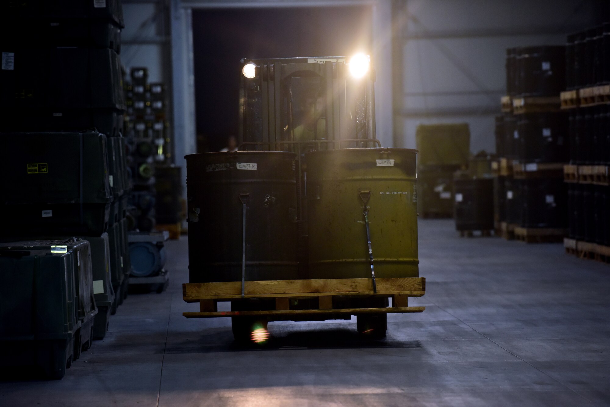 Barrels are transported by forklift in a warehouse during the night operations of Combat Ammunition Production Exercise 2019 on Aug. 7, 2019, at Aviano Air Base, Italy. Airmen are able to learn and enhance their skills during exercises allowing for improved combat readiness. (U.S. Air Force photo by Airman 1st Class Caleb House)