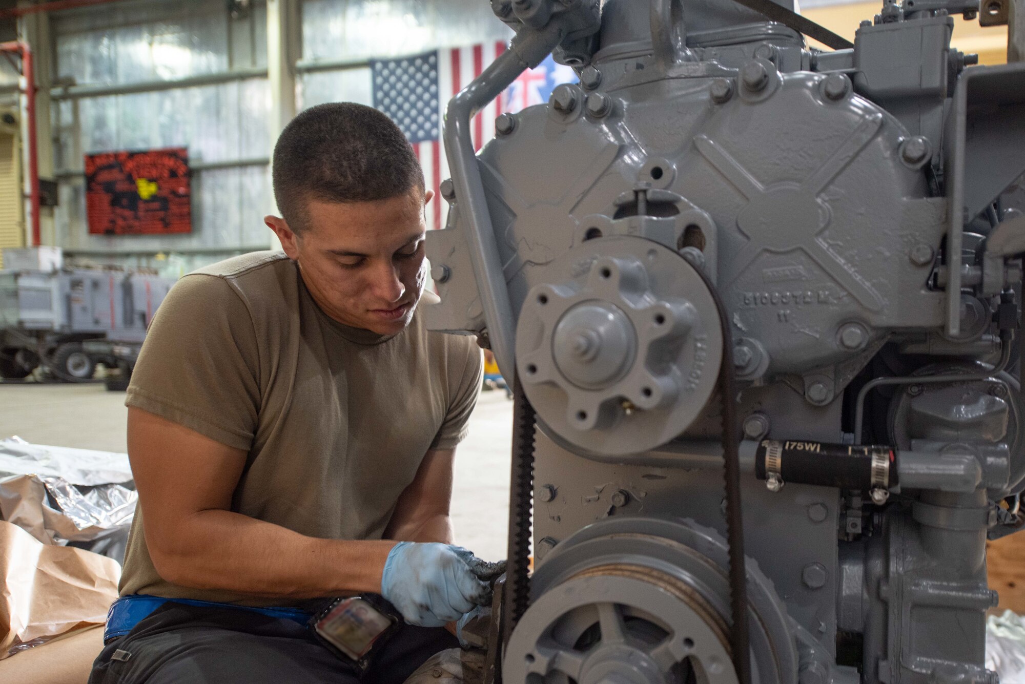Staff Sgt. Adan Nunez, 380th Expeditionary Maintenance Squadron aerospace ground equipment craftsman, attaches an alternator to a four-cylinder diesel engine July 30, 3019, at Al Dhafra Air Base, United Arab Emirates. The engine provides power to a -86 generator which delivers 115 watts to the aircraft. (U.S. Air Force photo by Staff Sgt. Chris Thornbury)