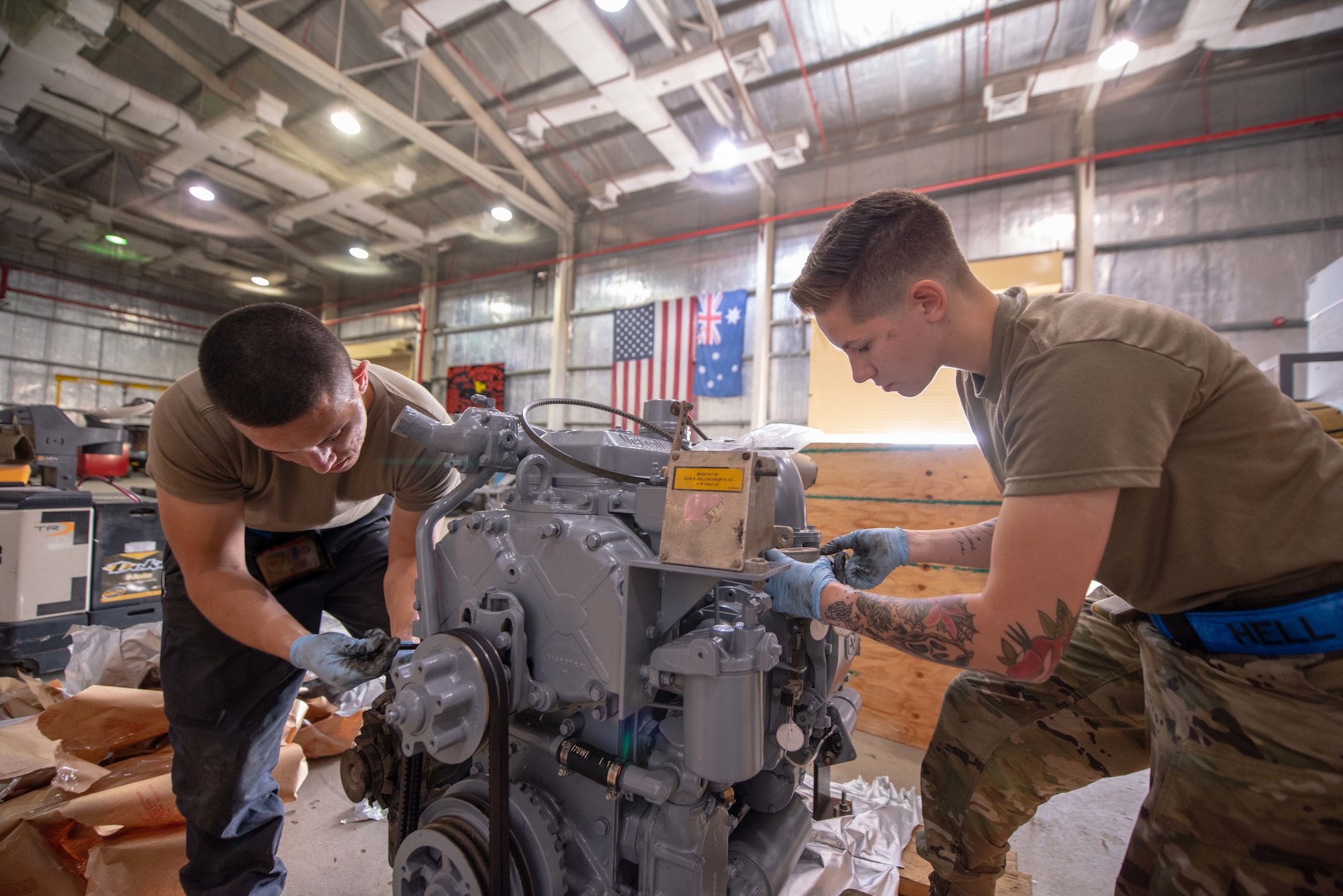 Staff Sgt. Adan Nunez and Senior Airman Maeson Bella, 380th Expeditionary Maintenance Squadron aerospace ground equipment technicians, work on a diesel engine July 30, 3019, at Al Dhafra Air Base, United Arab Emirates. Removing the old engine, rebuilding and installing the new engine is a three-day process. (U.S. Air Force photo by Staff Sgt. Chris Thornbury)