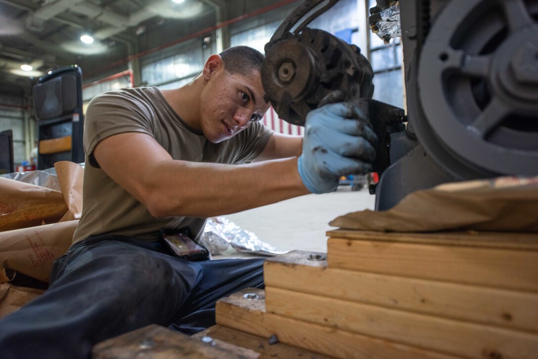 Staff Sgt. Adan Nunez, 380th Expeditionary Maintenance Squadron aerospace ground equipment craftsman, attaches an alternator to a four-cylinder diesel engine July 30, 3019, at Al Dhafra Air Base, United Arab Emirates. The engine provides power to a -86 generator which delivers 115 watts to the aircraft. (U.S. Air Force photo by Staff Sgt. Chris Thornbury)