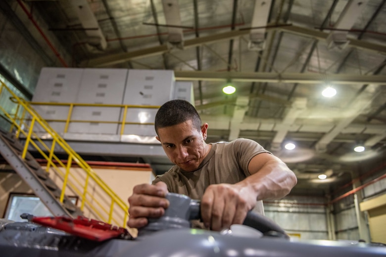 Staff Sgt. Adan Nunez, 380th Expeditionary Maintenance Squadron aerospace ground equipment craftsman, attaches an excess exhaust hose for a four-cylinder diesel engine July 30, 3019, at Al Dhafra Air Base, United Arab Emirates. The hose was pulled off an older engine to use on a newly rebuilt engine to power a -86 power cart’s generator. (U.S. Air Force photo by Staff Sgt. Chris Thornbury)