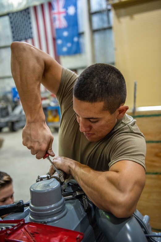 Staff Sgt. Adan Nunez, 380th Expeditionary Maintenance Squadron aerospace ground equipment craftsman, attaches an excess exhaust hose for a four-cylinder diesel engine July 30, 3019, at Al Dhafra Air Base, United Arab Emirates. The hose was pulled off an older engine to use on a newly rebuilt engine to power a -86 power cart’s generator. (U.S. Air Force photo by Staff Sgt. Chris Thornbury)