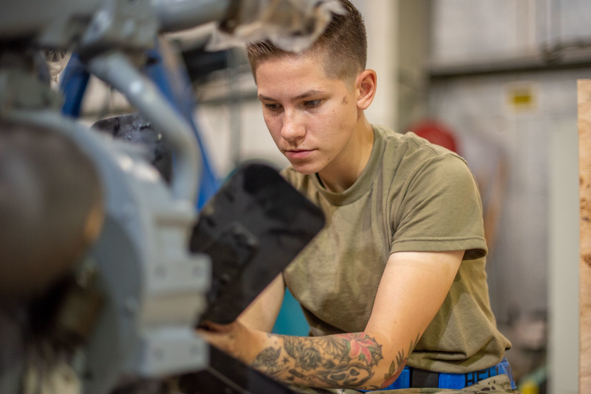 Senior Airman Maeson Bella, 380th Expeditionary Maintenance Squadron aerospace ground equipment journeyman, attaches a fan to a newly rebuilt -86 engine July 30, 3019, at Al Dhafra Air Base, United Arab Emirates. Keeping the unit cool will increase the lifespan in the intense desert summer heat. (U.S. Air Force photo by Staff Sgt. Chris Thornbury)
