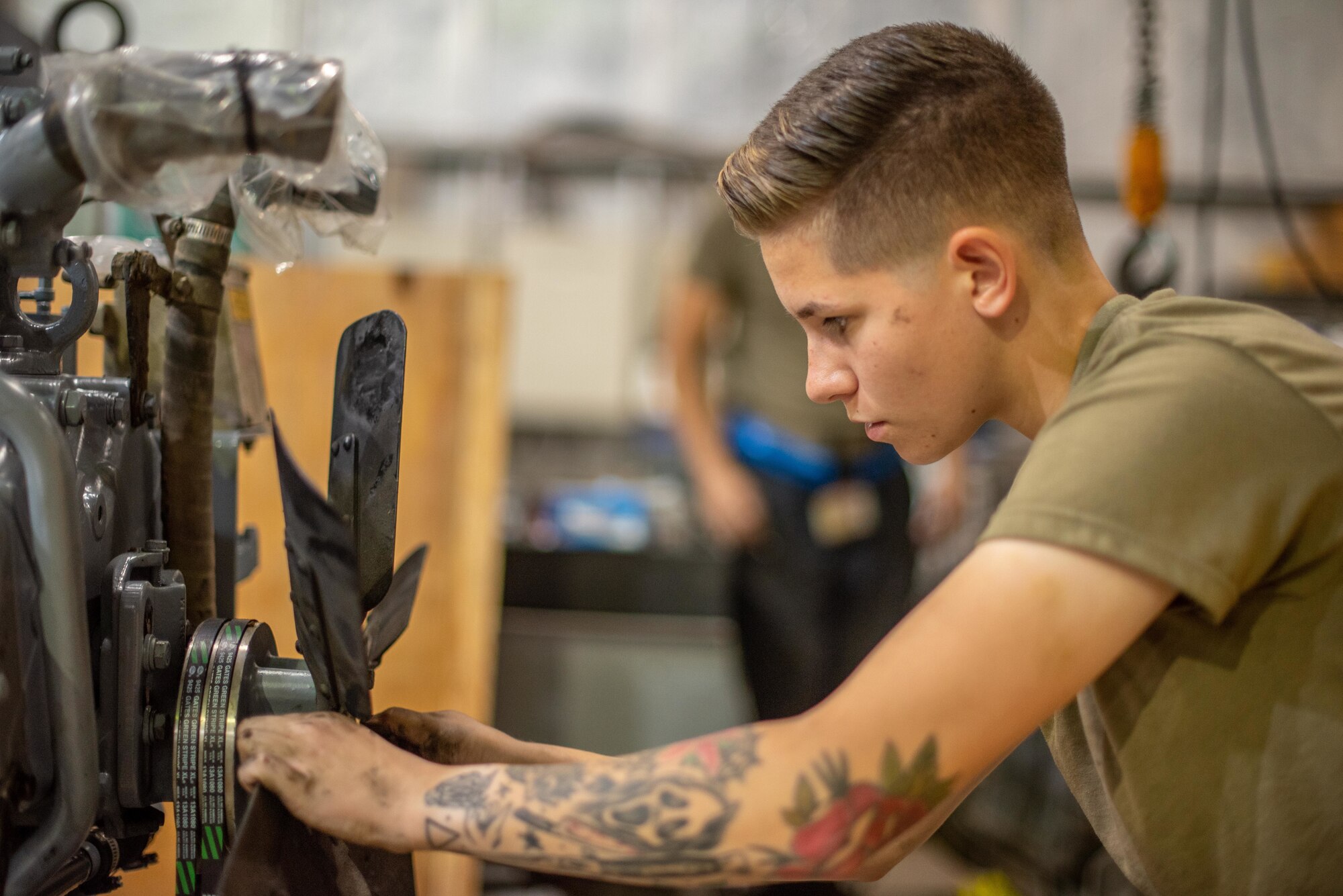 Senior Airman Maeson Bella, 380th Expeditionary Maintenance Squadron aerospace ground equipment journeyman, attaches a fan to a newly rebuilt -86 engine July 30, 3019, at Al Dhafra Air Base, United Arab Emirates. Keeping the unit cool will increase the lifespan in the intense desert summer heat. (U.S. Air Force photo by Staff Sgt. Chris Thornbury)