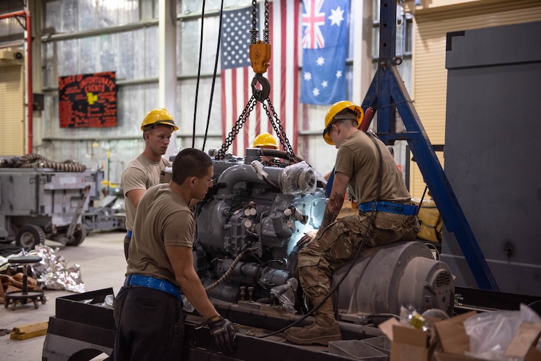 A team of 380th Expeditionary Maintenance Squadron aerospace ground equipment technicians install a newly rebuilt diesel engine into a -86 power cart July 30, 3019, at Al Dhafra Air Base, United Arab Emirates. The engine provides power to a -86 generator which delivers 115 watts to the aircraft. (U.S. Air Force photo by Staff Sgt. Chris Thornbury)